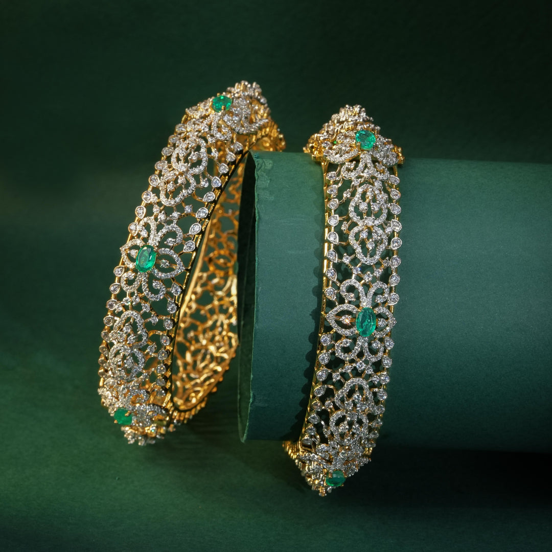 92.5 silver CZ bangles with floral motifs, and semi-precious emerald stones by Sri Fine Jewellery, Hyderabad.
(https://www.srifinejewellery.com)