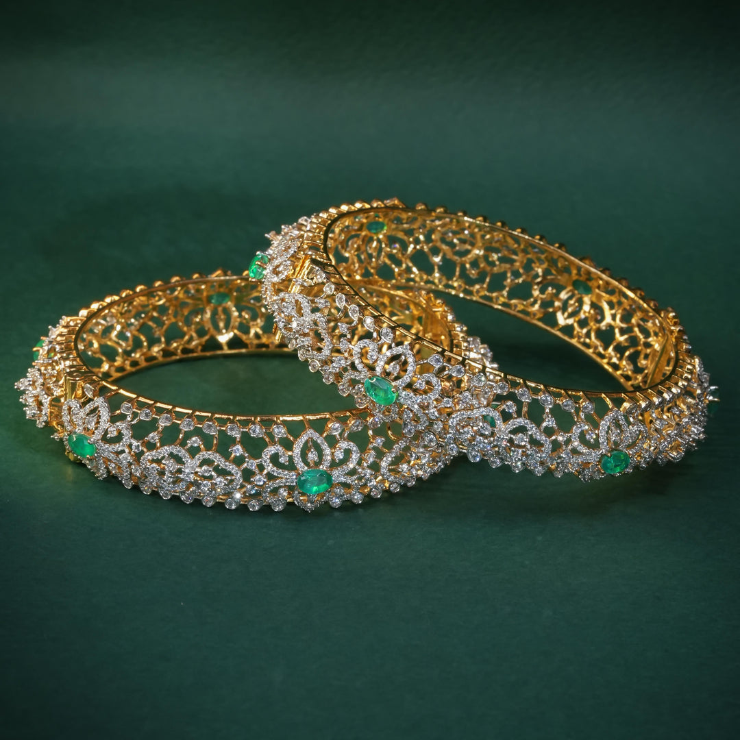 92.5 silver CZ bangles with floral motifs, and semi-precious emerald stones by Sri Fine Jewellery, Hyderabad.
(https://www.srifinejewellery.com)