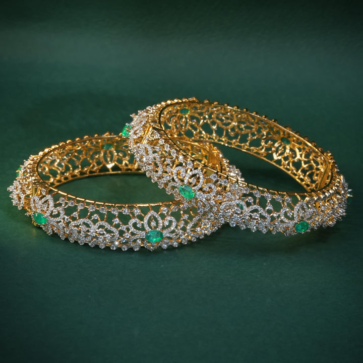 92.5 silver CZ bangles with floral motifs, and semi-precious emerald stones by Sri Fine Jewellery, Hyderabad.
(https://www.srifinejewellery.com)