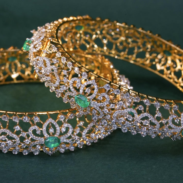 92.5 silver CZ bangles with floral motifs, and semi-precious emerald stones by Sri Fine Jewellery, Hyderabad.
(https://www.srifinejewellery.com)