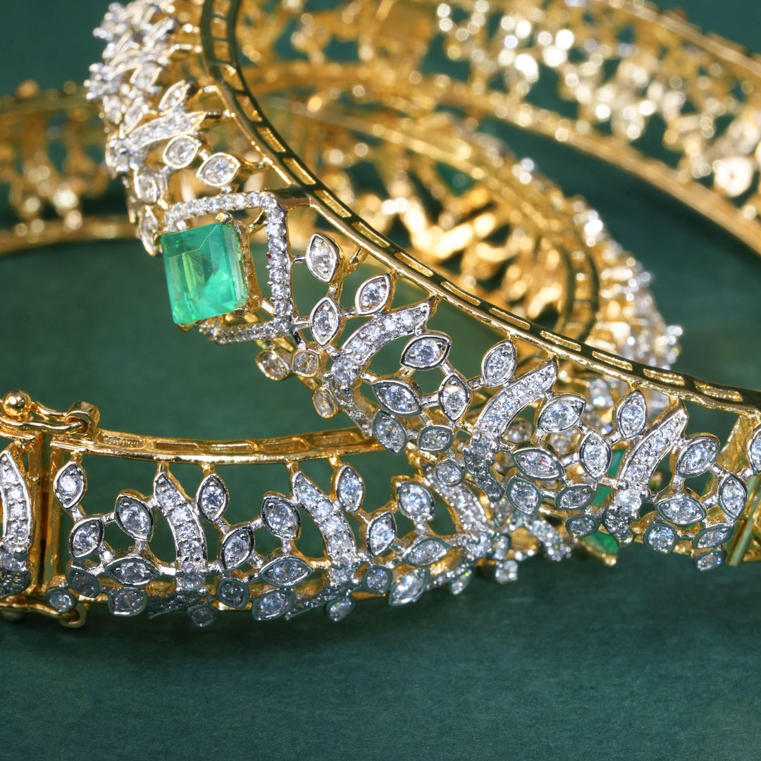 92.5 silver CZ bangles with floral motifs, and semi-precious russian emerald stones by Sri Fine Jewellery, Hyderabad.
(https://www.srifinejewellery.com)