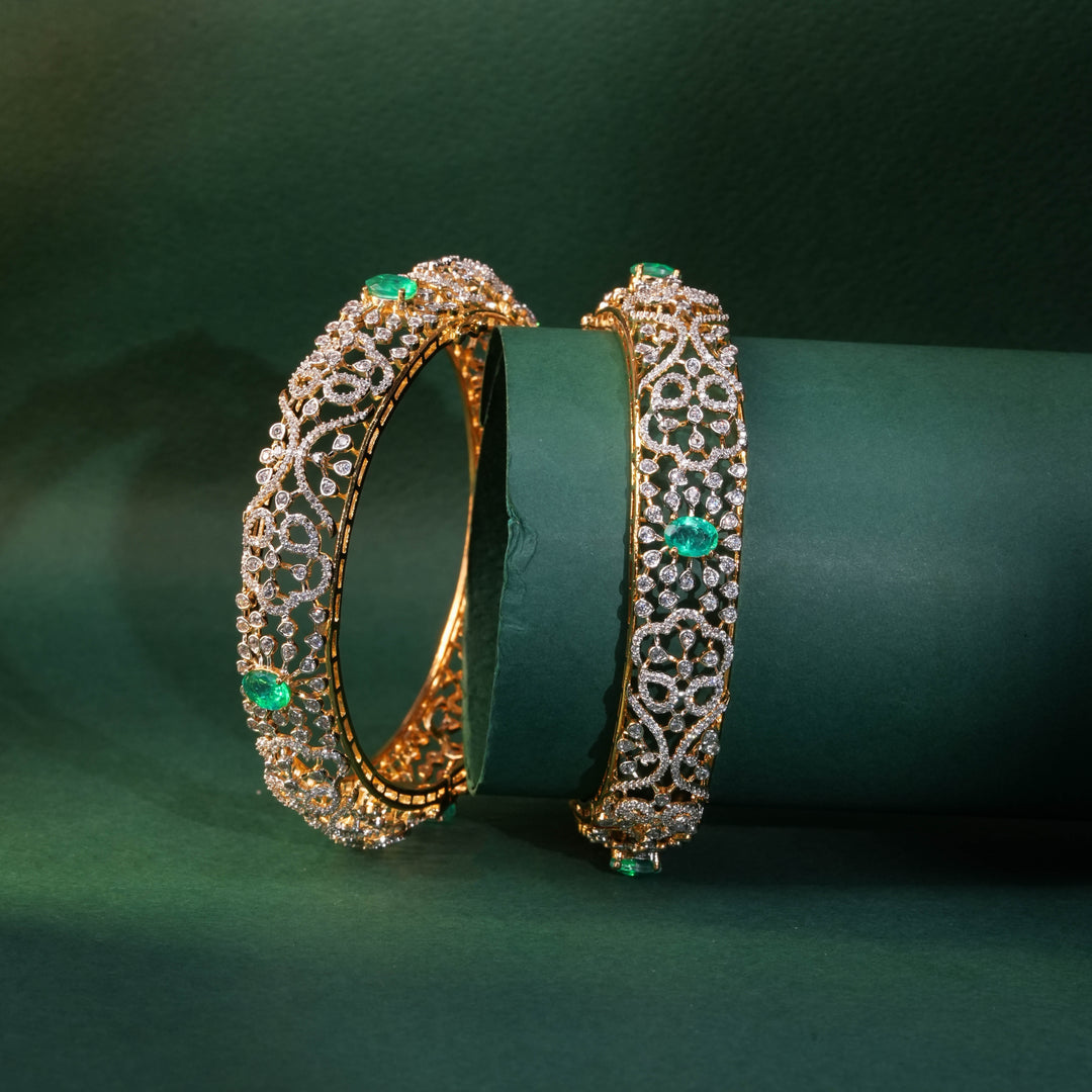 92.5 silver CZ bangles with floral motifs, and semi-precious russian emerald stones by Sri Fine Jewellery, Hyderabad.
(https://www.srifinejewellery.com)