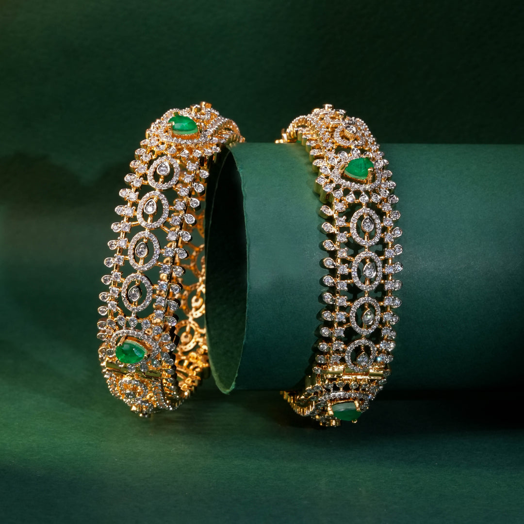 92.5 silver CZ bangles with floral motifs, and semi-precious emerald stones by Sri Fine Jewellery, Hyderabad.
(https://www.srifinejewellery.com)