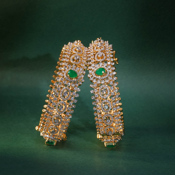 92.5 silver CZ bangles with floral motifs, and semi-precious emerald stones by Sri Fine Jewellery, Hyderabad.
(https://www.srifinejewellery.com)