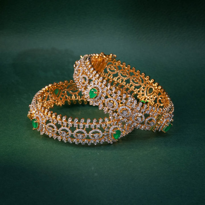 92.5 silver CZ bangles with floral motifs, and semi-precious emerald stones by Sri Fine Jewellery, Hyderabad.
(https://www.srifinejewellery.com)