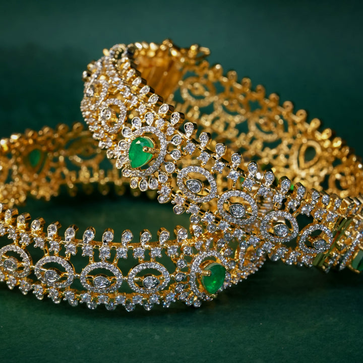 92.5 silver CZ bangles with floral motifs, and semi-precious emerald stones by Sri Fine Jewellery, Hyderabad.
(https://www.srifinejewellery.com)