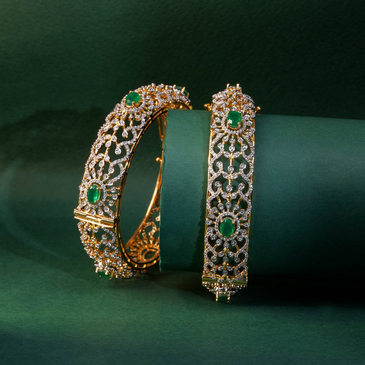 92.5 silver CZ bangles with floral motifs, and semi-precious emerald stones by Sri Fine Jewellery, Hyderabad.
(https://www.srifinejewellery.com)