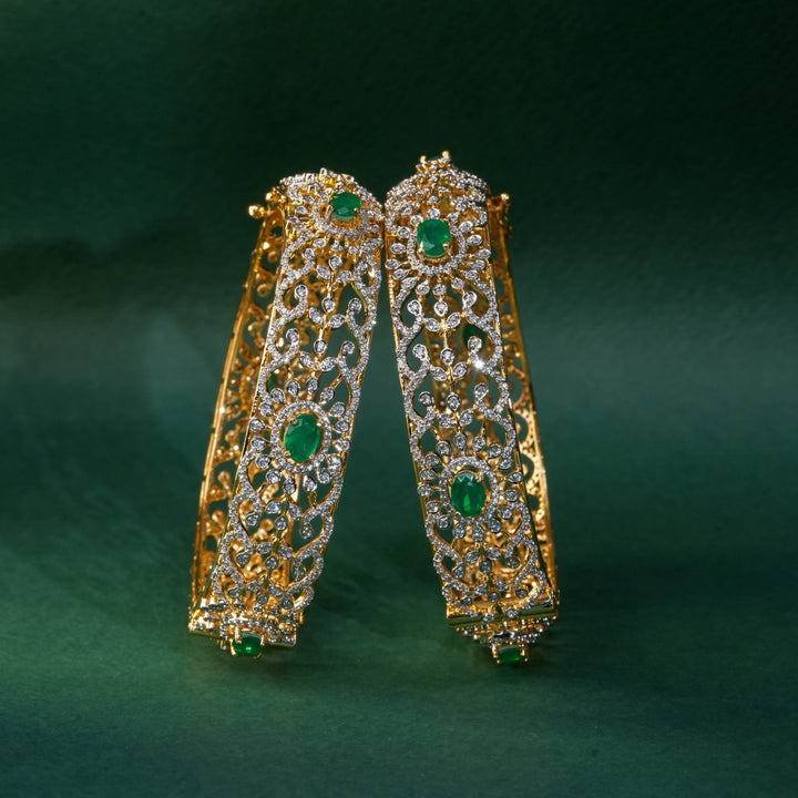 92.5 silver CZ bangles with floral motifs, and semi-precious emerald stones by Sri Fine Jewellery, Hyderabad.
(https://www.srifinejewellery.com)