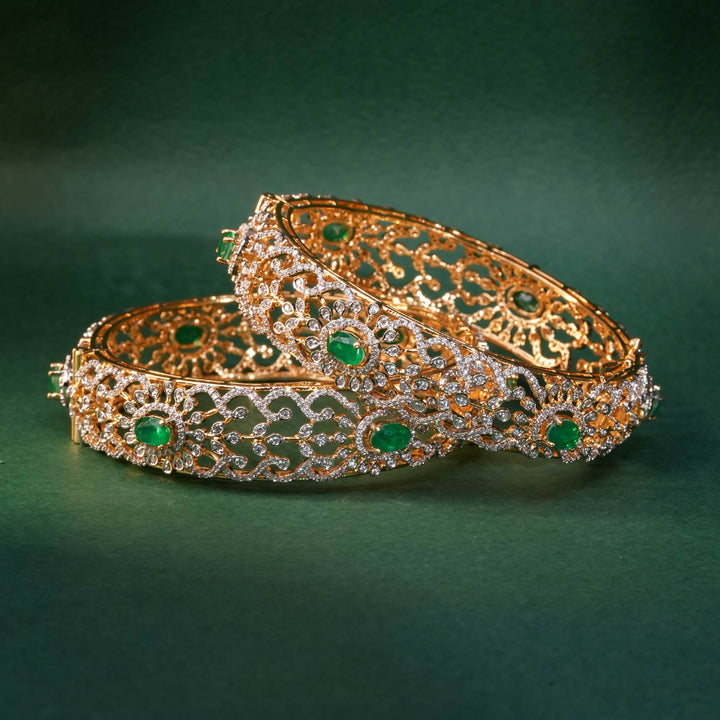 92.5 silver CZ bangles with floral motifs, and semi-precious emerald stones by Sri Fine Jewellery, Hyderabad.
(https://www.srifinejewellery.com)