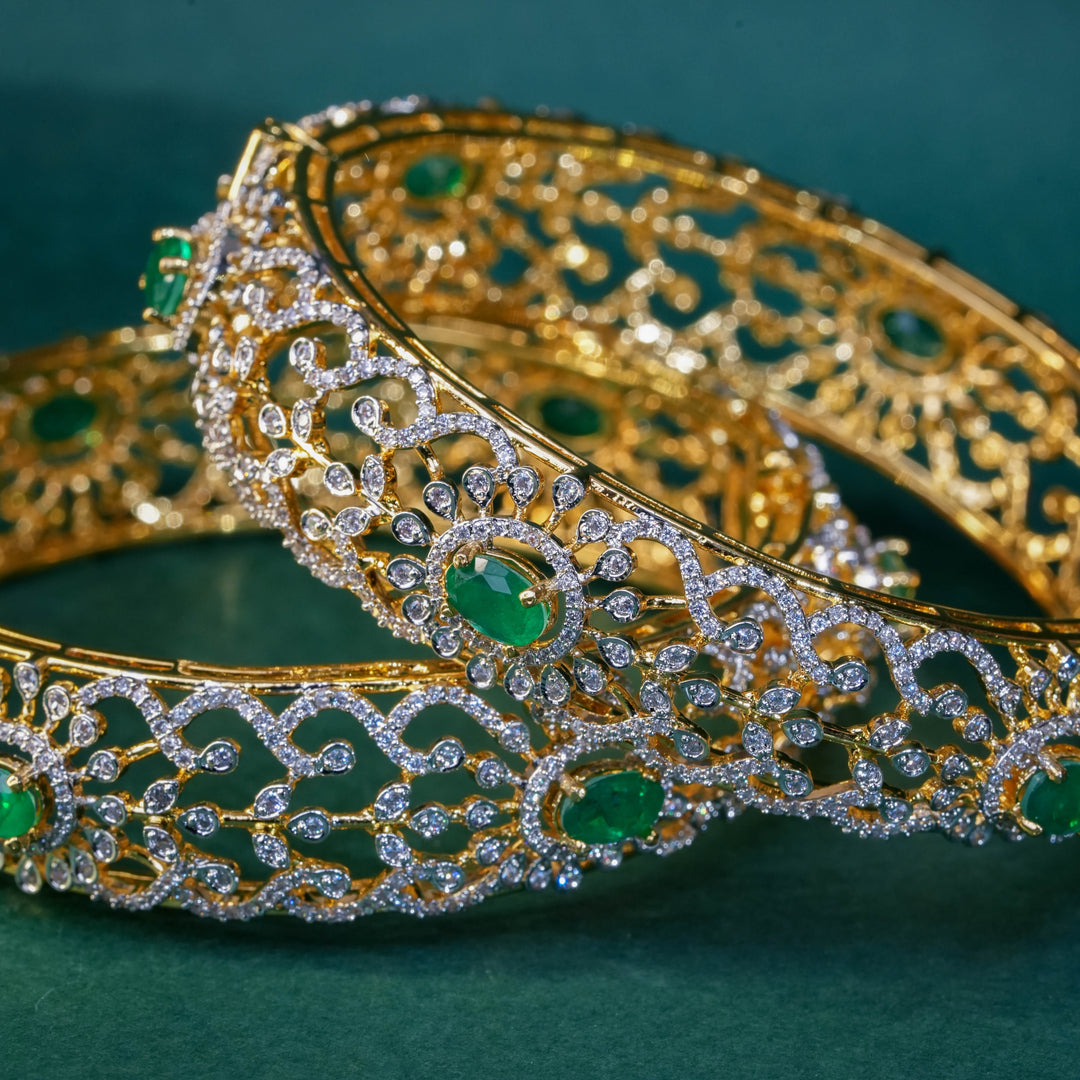 92.5 silver CZ bangles with floral motifs, and semi-precious emerald stones by Sri Fine Jewellery, Hyderabad.
(https://www.srifinejewellery.com)