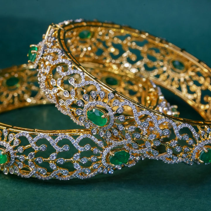 92.5 silver CZ bangles with floral motifs, and semi-precious emerald stones by Sri Fine Jewellery, Hyderabad.
(https://www.srifinejewellery.com)
