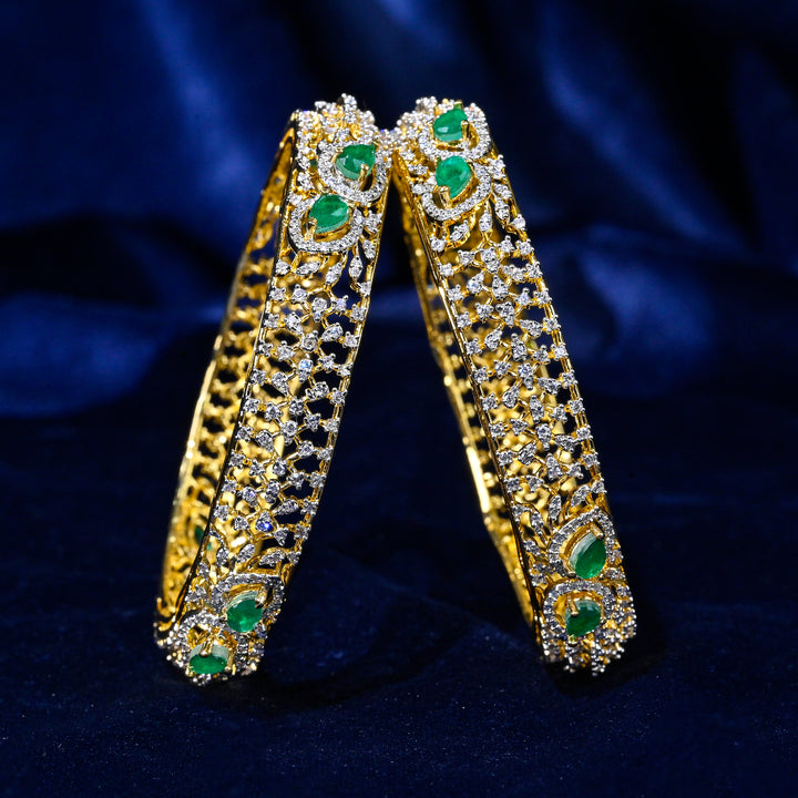 92.5 silver CZ bangles with floral motifs, and semi-precious emerald stones by Sri Fine Jewellery, Hyderabad.
(https://www.srifinejewellery.com)