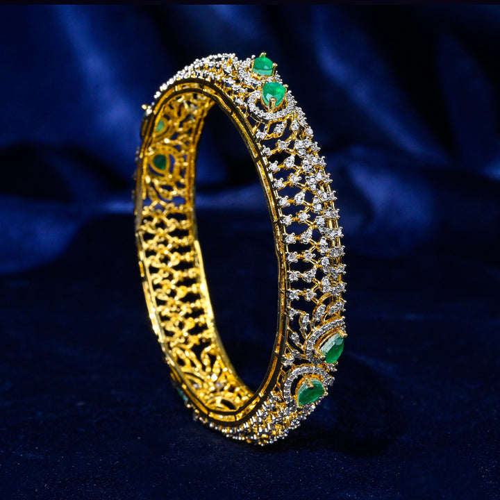 92.5 silver CZ bangles with floral motifs, and semi-precious emerald stones by Sri Fine Jewellery, Hyderabad.
(https://www.srifinejewellery.com)