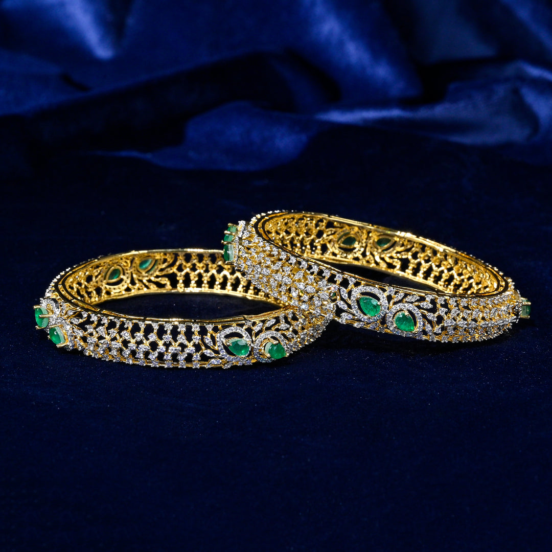 92.5 silver CZ bangles with floral motifs, and semi-precious emerald stones by Sri Fine Jewellery, Hyderabad.
(https://www.srifinejewellery.com)