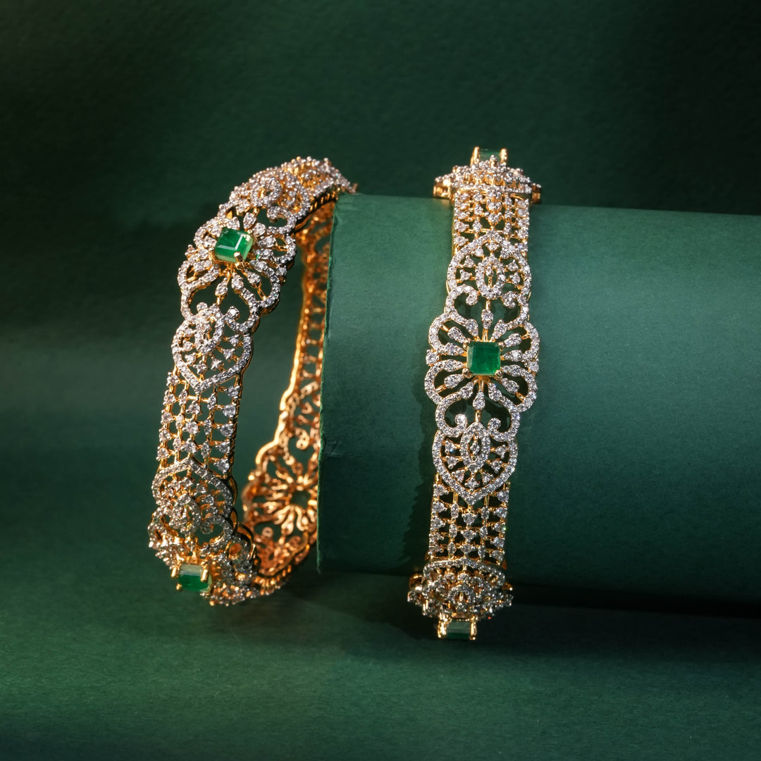92.5 silver CZ bangles with floral motifs, and semi-precious emerald stones by Sri Fine Jewellery, Hyderabad.
(https://www.srifinejewellery.com)