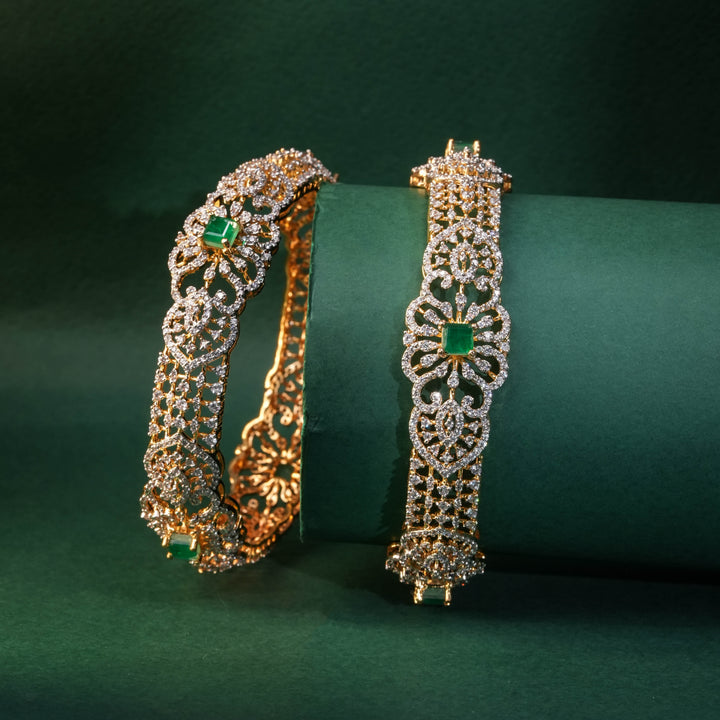 92.5 silver CZ bangles with floral motifs, and semi-precious emerald stones by Sri Fine Jewellery, Hyderabad.
(https://www.srifinejewellery.com)