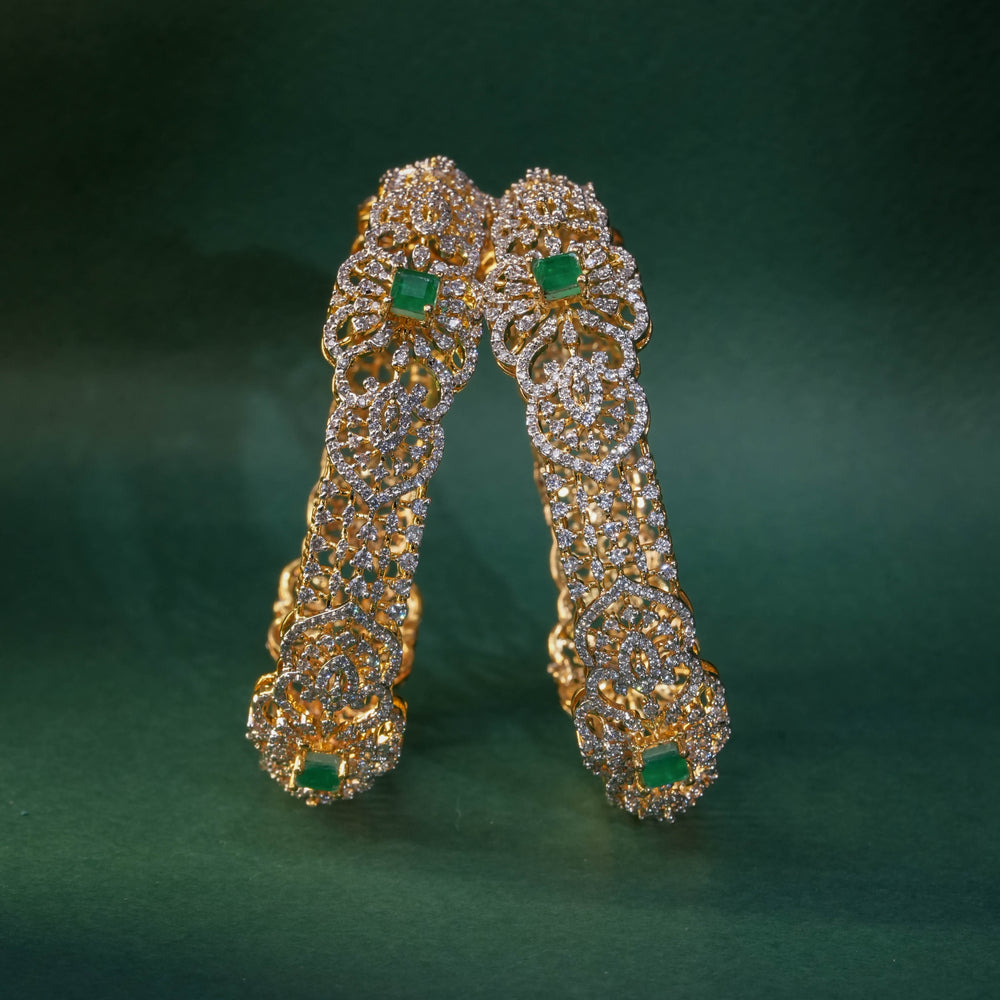 92.5 silver CZ bangles with floral motifs, and semi-precious emerald stones by Sri Fine Jewellery, Hyderabad.
(https://www.srifinejewellery.com)
