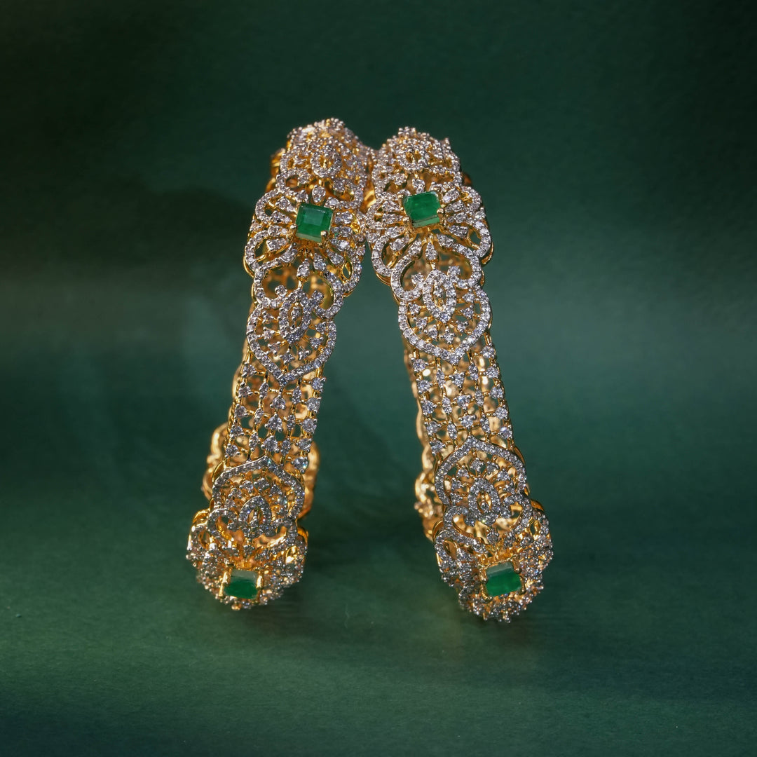 92.5 silver CZ bangles with floral motifs, and semi-precious emerald stones by Sri Fine Jewellery, Hyderabad.
(https://www.srifinejewellery.com)
