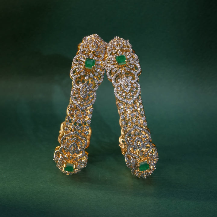 92.5 silver CZ bangles with floral motifs, and semi-precious emerald stones by Sri Fine Jewellery, Hyderabad.
(https://www.srifinejewellery.com)