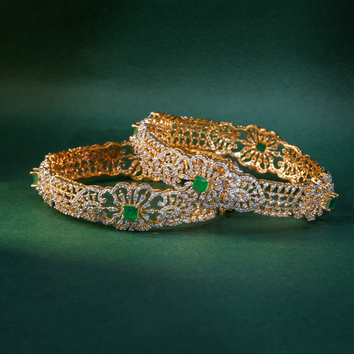 92.5 silver CZ bangles with floral motifs, and semi-precious emerald stones by Sri Fine Jewellery, Hyderabad.
(https://www.srifinejewellery.com)