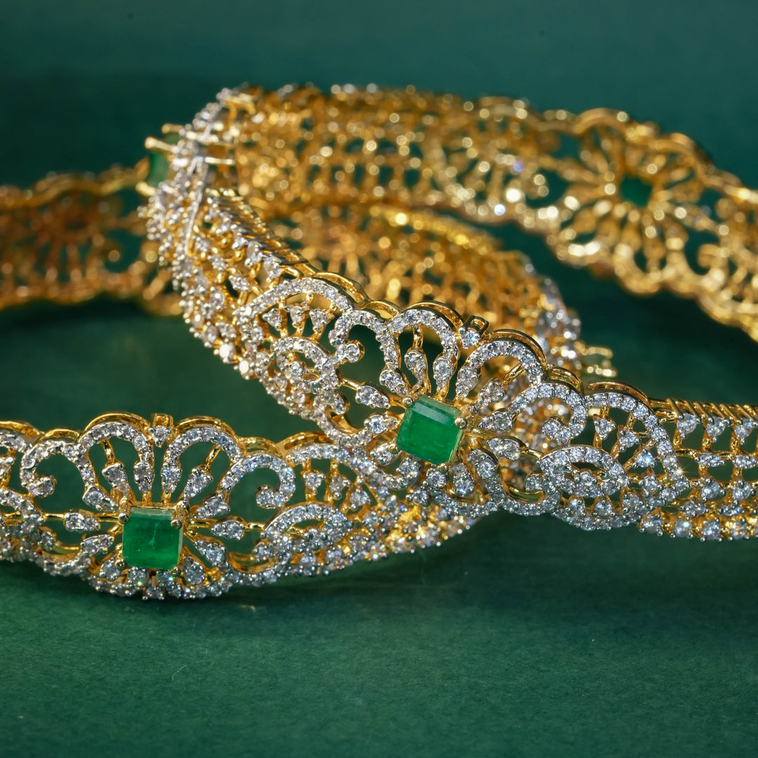 92.5 silver CZ bangles with floral motifs, and semi-precious emerald stones by Sri Fine Jewellery, Hyderabad.
(https://www.srifinejewellery.com)
