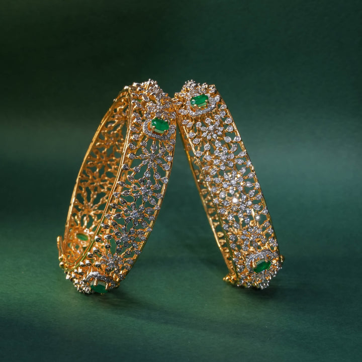 92.5 silver CZ bangles with floral motifs, and semi-precious emerald stones by Sri Fine Jewellery, Hyderabad.
(https://www.srifinejewellery.com)