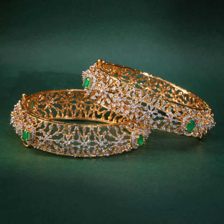 92.5 silver CZ bangles with floral motifs, and semi-precious emerald stones by Sri Fine Jewellery, Hyderabad.
(https://www.srifinejewellery.com)