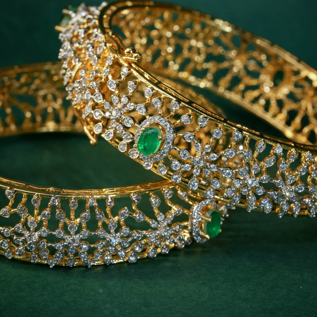 92.5 silver CZ bangles with floral motifs, and semi-precious emerald stones by Sri Fine Jewellery, Hyderabad.
(https://www.srifinejewellery.com)