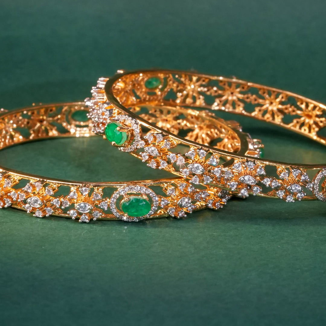 92.5 silver CZ bangles with floral motifs and gold-like finish by Sri Fine Jewellery, Hyderabad.
(https://www.srifinejewellery.com)