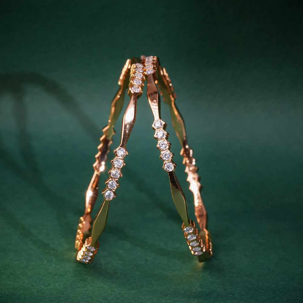 92.5 silver CZ bangles with floral motifs and gold-like finish by Sri Fine Jewellery, Hyderabad.
(https://www.srifinejewellery.com)
