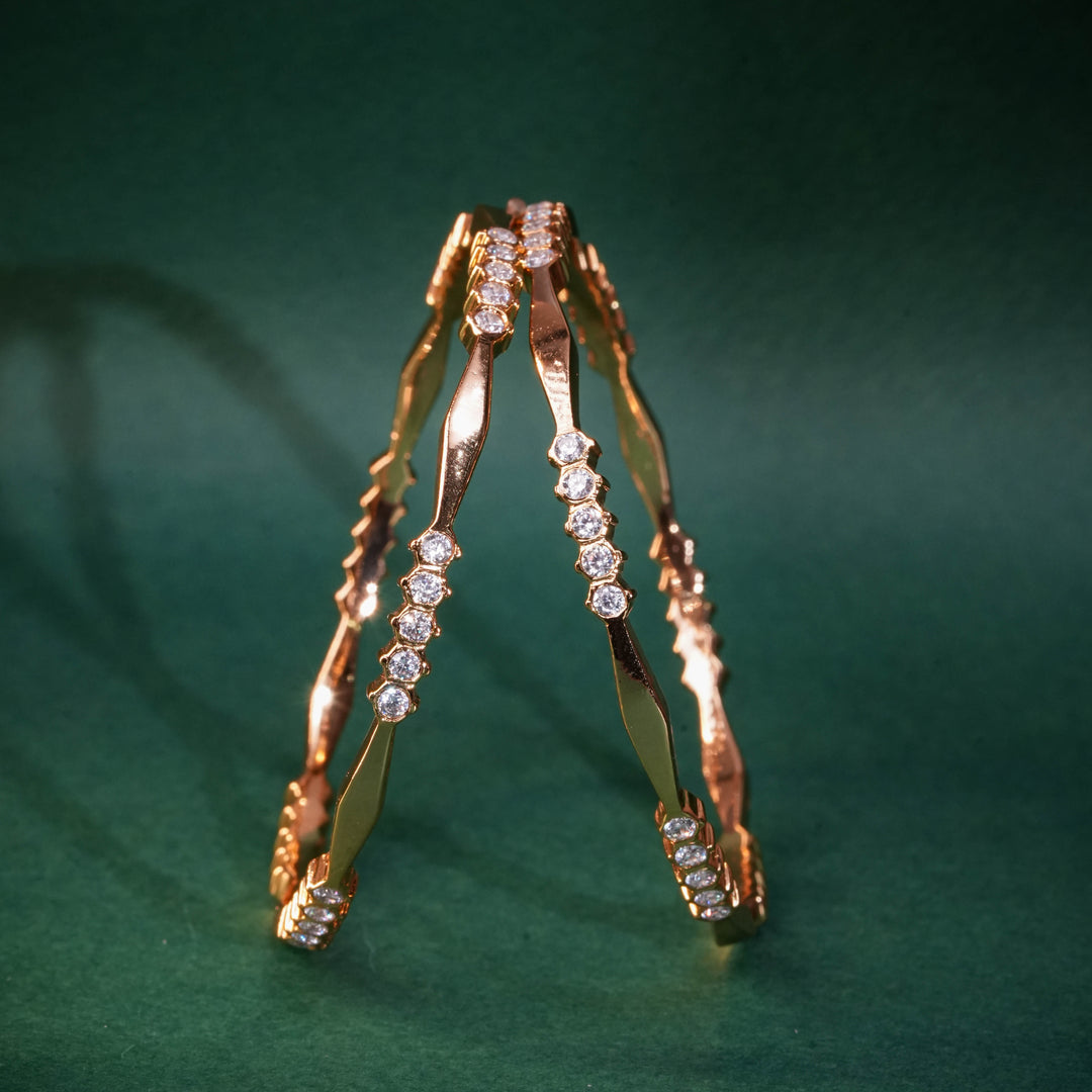 92.5 silver CZ bangles with floral motifs and gold-like finish by Sri Fine Jewellery, Hyderabad.
(https://www.srifinejewellery.com)