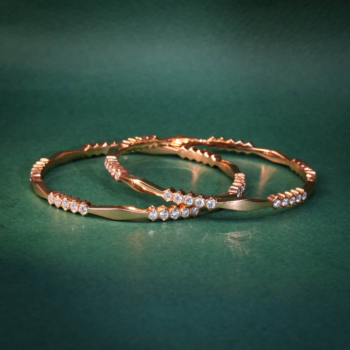 92.5 silver CZ bangles with floral motifs and gold-like finish by Sri Fine Jewellery, Hyderabad.
(https://www.srifinejewellery.com)