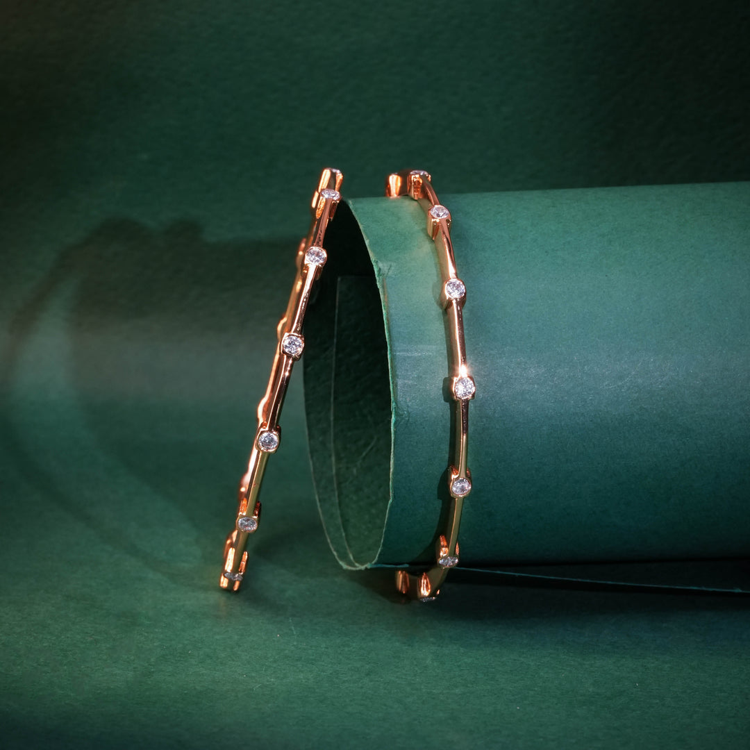 92.5 silver CZ bangles with floral motifs and gold-like finish by Sri Fine Jewellery, Hyderabad.
(https://www.srifinejewellery.com)