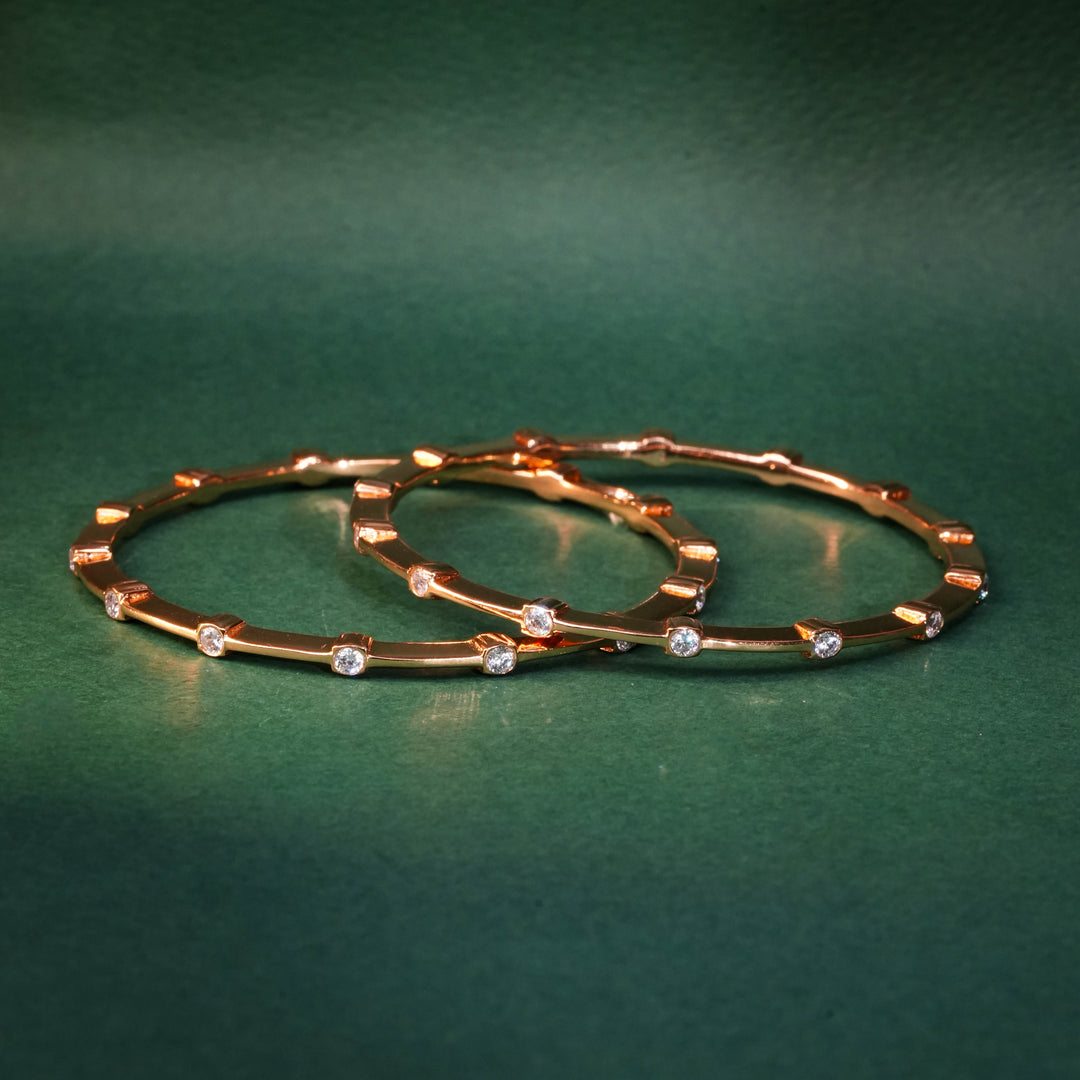 92.5 silver CZ bangles with floral motifs and gold-like finish by Sri Fine Jewellery, Hyderabad.
(https://www.srifinejewellery.com)