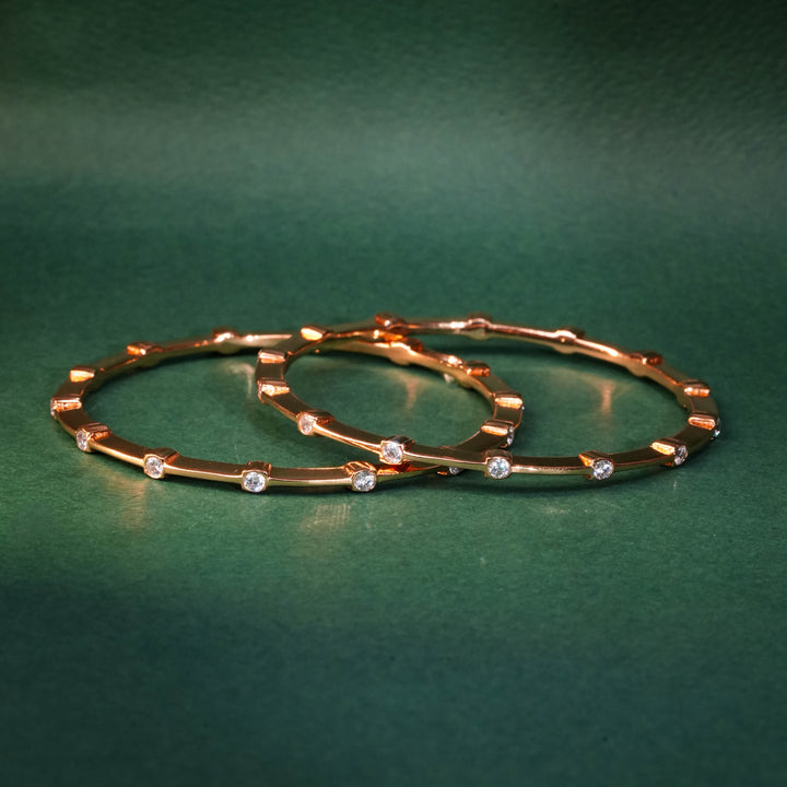 92.5 silver CZ bangles with floral motifs and gold-like finish by Sri Fine Jewellery, Hyderabad.
(https://www.srifinejewellery.com)