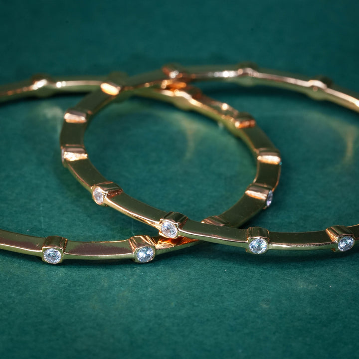 92.5 silver CZ bangles with floral motifs and gold-like finish by Sri Fine Jewellery, Hyderabad.
(https://www.srifinejewellery.com)