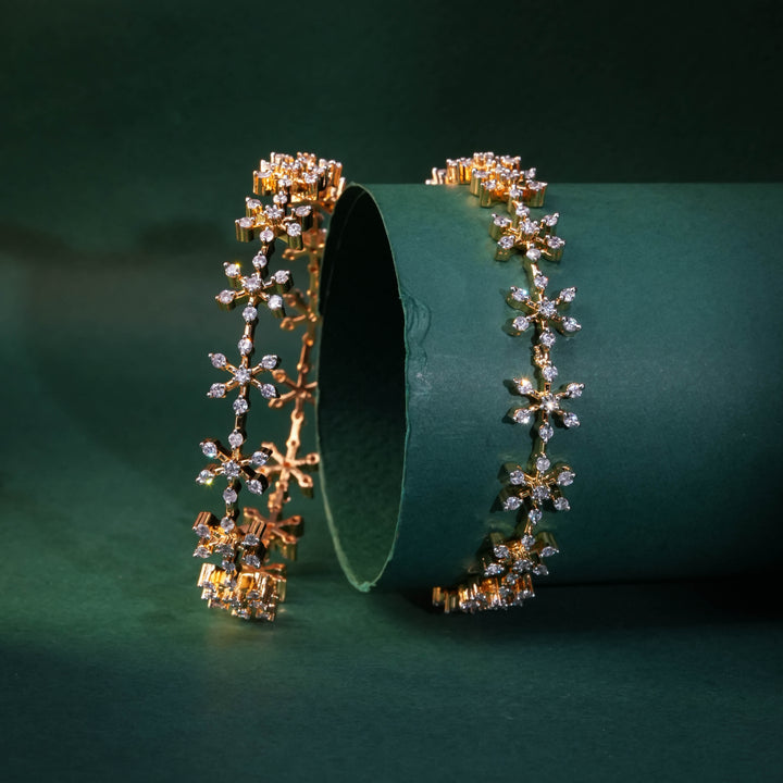 92.5 silver CZ bangles with floral motifs and gold-like finish by Sri Fine Jewellery, Hyderabad.
(https://www.srifinejewellery.com)