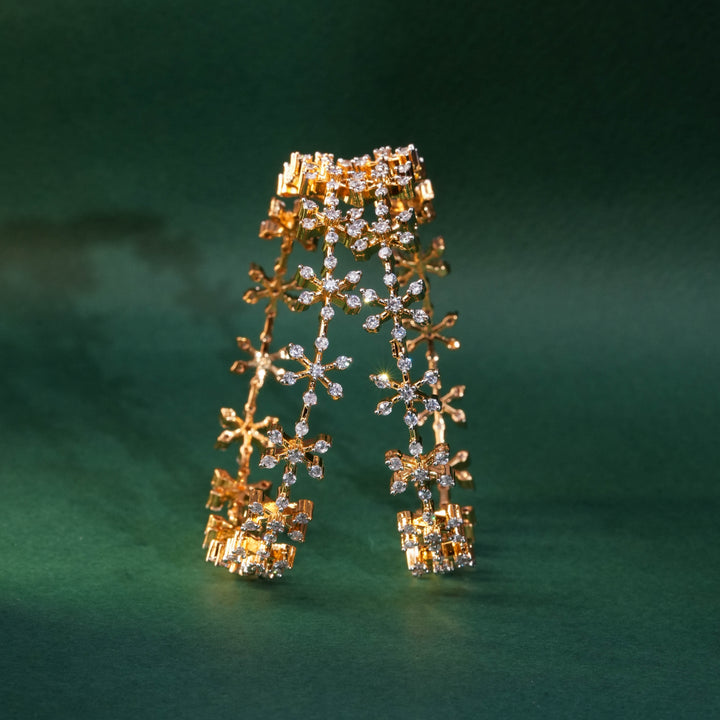 92.5 silver CZ bangles with floral motifs and gold-like finish by Sri Fine Jewellery, Hyderabad.
(https://www.srifinejewellery.com)