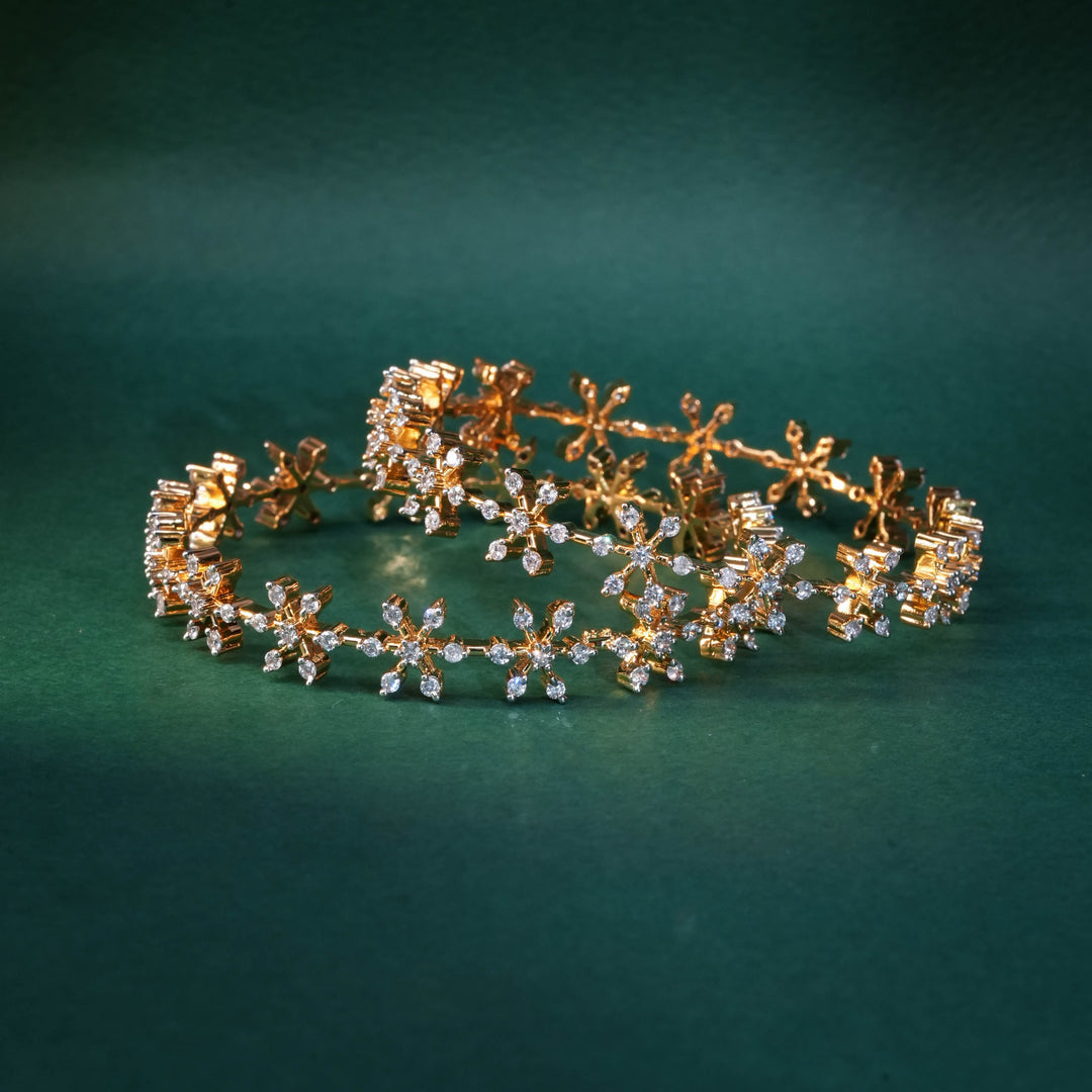 92.5 silver CZ bangles with floral motifs and gold-like finish by Sri Fine Jewellery, Hyderabad.
(https://www.srifinejewellery.com)