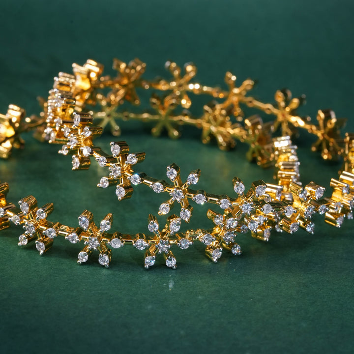 92.5 silver CZ bangles with floral motifs and gold-like finish by Sri Fine Jewellery, Hyderabad.
(https://www.srifinejewellery.com)