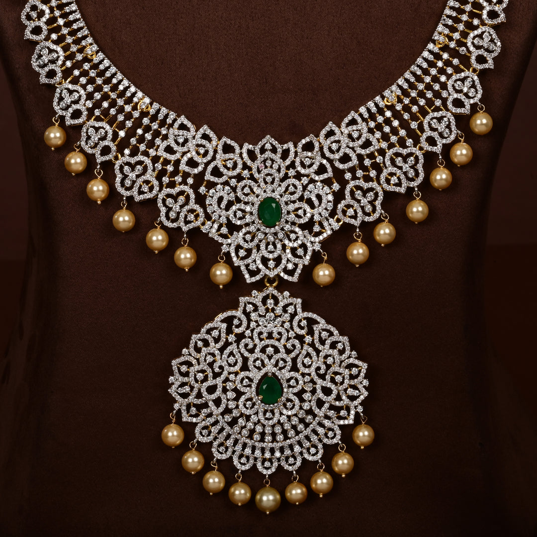 Close-up view of luxury diamond-look silver cz emerald necklace set with premium cz stones, semi-precious emerald stone and  pearl drops in 92.5 silver, bridal wedding jewellery with gold finish by Sri Fine Jewellery Punjagutta Hyderabad.