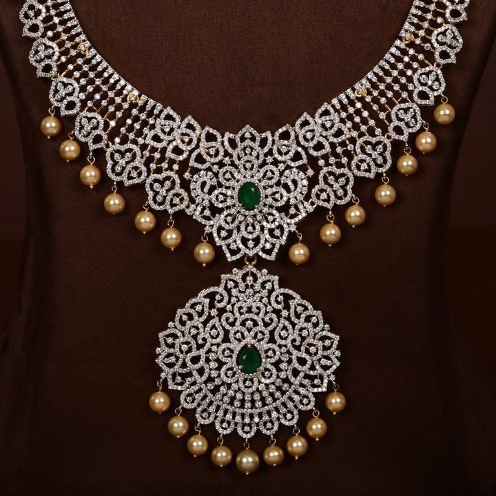 Close-up view of luxury diamond-look silver cz emerald necklace set with premium cz stones, semi-precious emerald stone and  pearl drops in 92.5 silver, bridal wedding jewellery with gold finish by Sri Fine Jewellery Punjagutta Hyderabad.