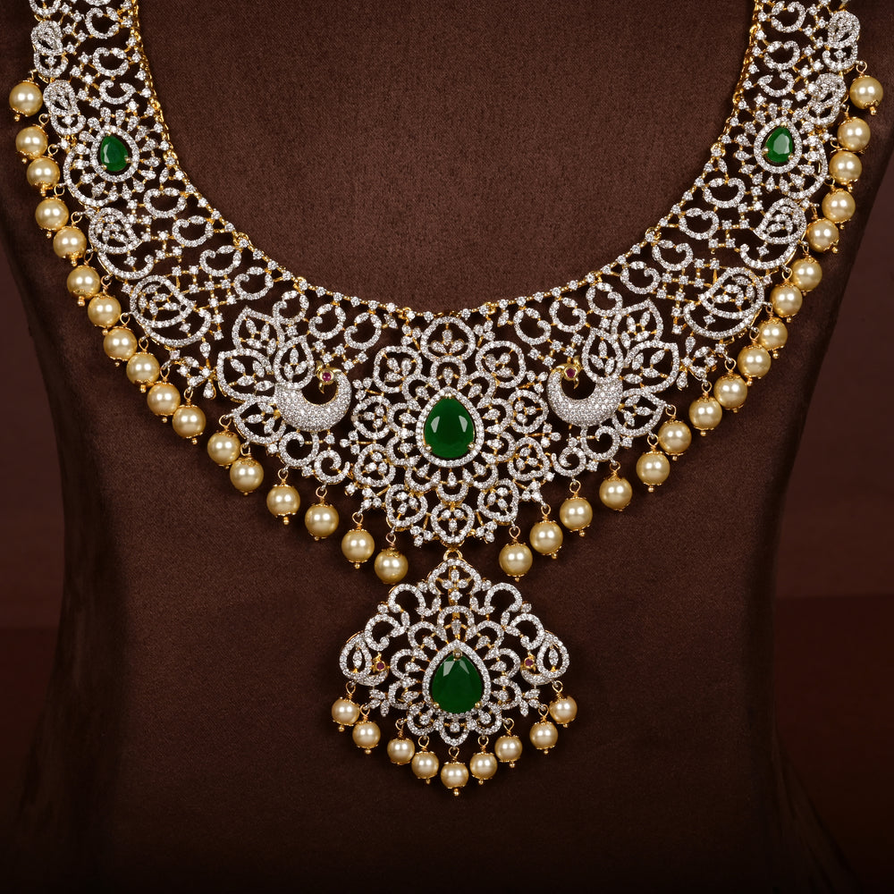 Close-up view of luxury diamond-look silver cz emerald necklace with premium cz stones, semi-precious emerald stone and  pearl drops in 92.5 silver, bridal wedding jewellery with gold finish by Sri Fine Jewellery Punjagutta Hyderabad.