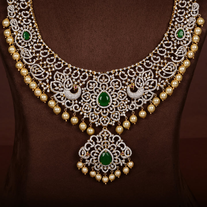 Close-up view of luxury diamond-look silver cz emerald necklace with premium cz stones, semi-precious emerald stone and  pearl drops in 92.5 silver, bridal wedding jewellery with gold finish by Sri Fine Jewellery Punjagutta Hyderabad.