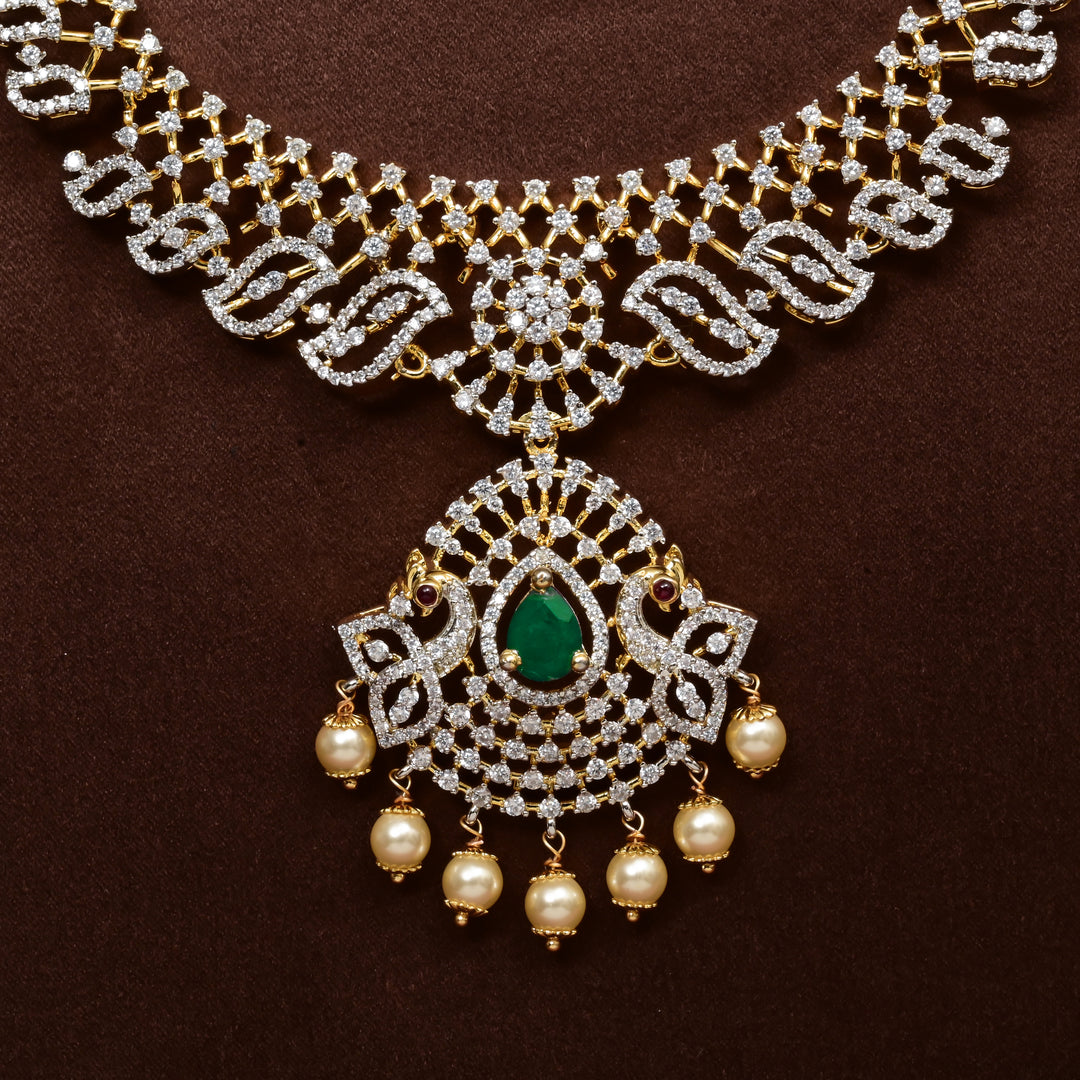 Close-up view of luxury diamond-look silver cz emerald necklace with premium cz stones, semi-precious emerald stone and  pearl drops in 92.5 silver, bridal wedding jewellery with gold finish by Sri Fine Jewellery Punjagutta Hyderabad.
