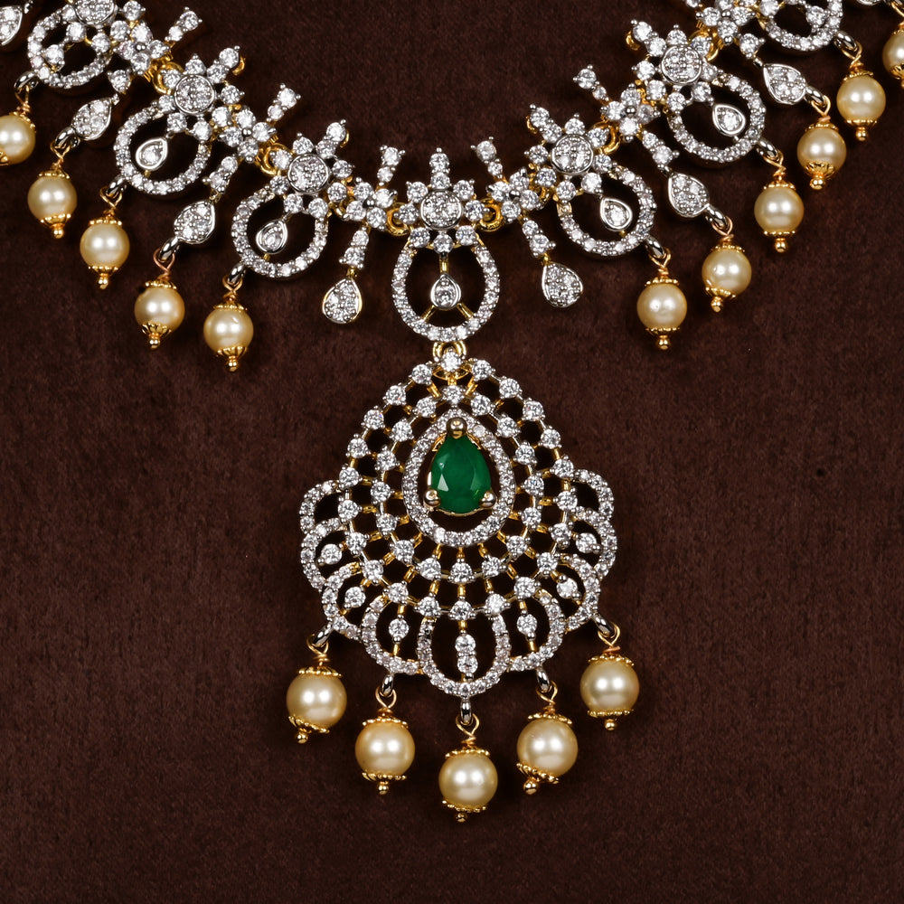 Close-up view of luxury diamond-look silver cz emerald necklace with premium cz stones, semi-precious emerald stone and  pearl drops in 92.5 silver, bridal wedding jewellery with gold finish by Sri Fine Jewellery Punjagutta Hyderabad.