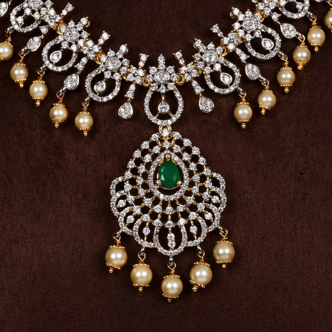 Close-up view of luxury diamond-look silver cz emerald necklace with premium cz stones, semi-precious emerald stone and  pearl drops in 92.5 silver, bridal wedding jewellery with gold finish by Sri Fine Jewellery Punjagutta Hyderabad.