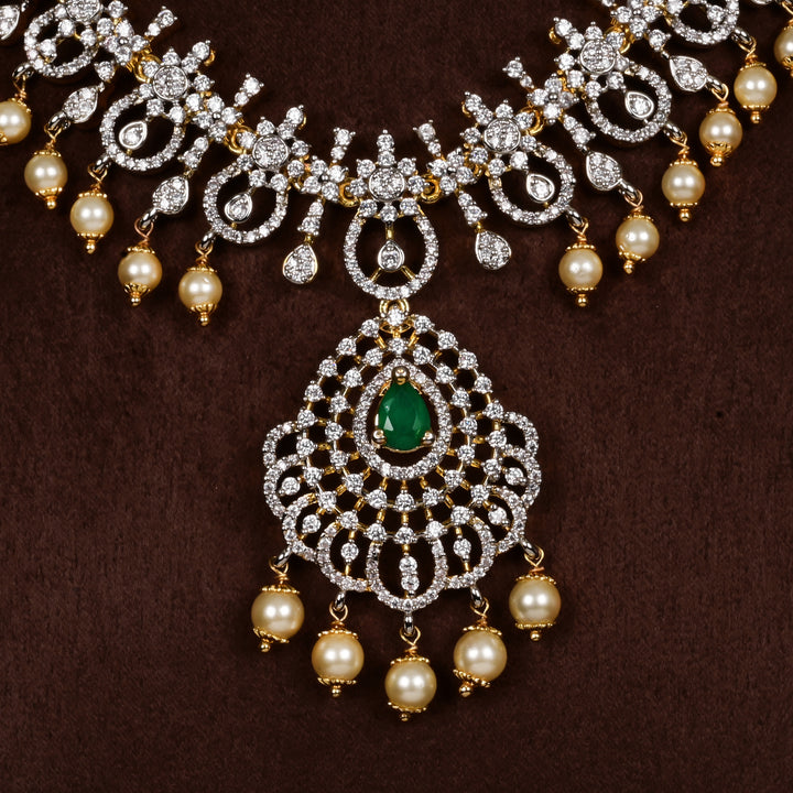 Close-up view of luxury diamond-look silver cz emerald necklace with premium cz stones, semi-precious emerald stone and  pearl drops in 92.5 silver, bridal wedding jewellery with gold finish by Sri Fine Jewellery Punjagutta Hyderabad.