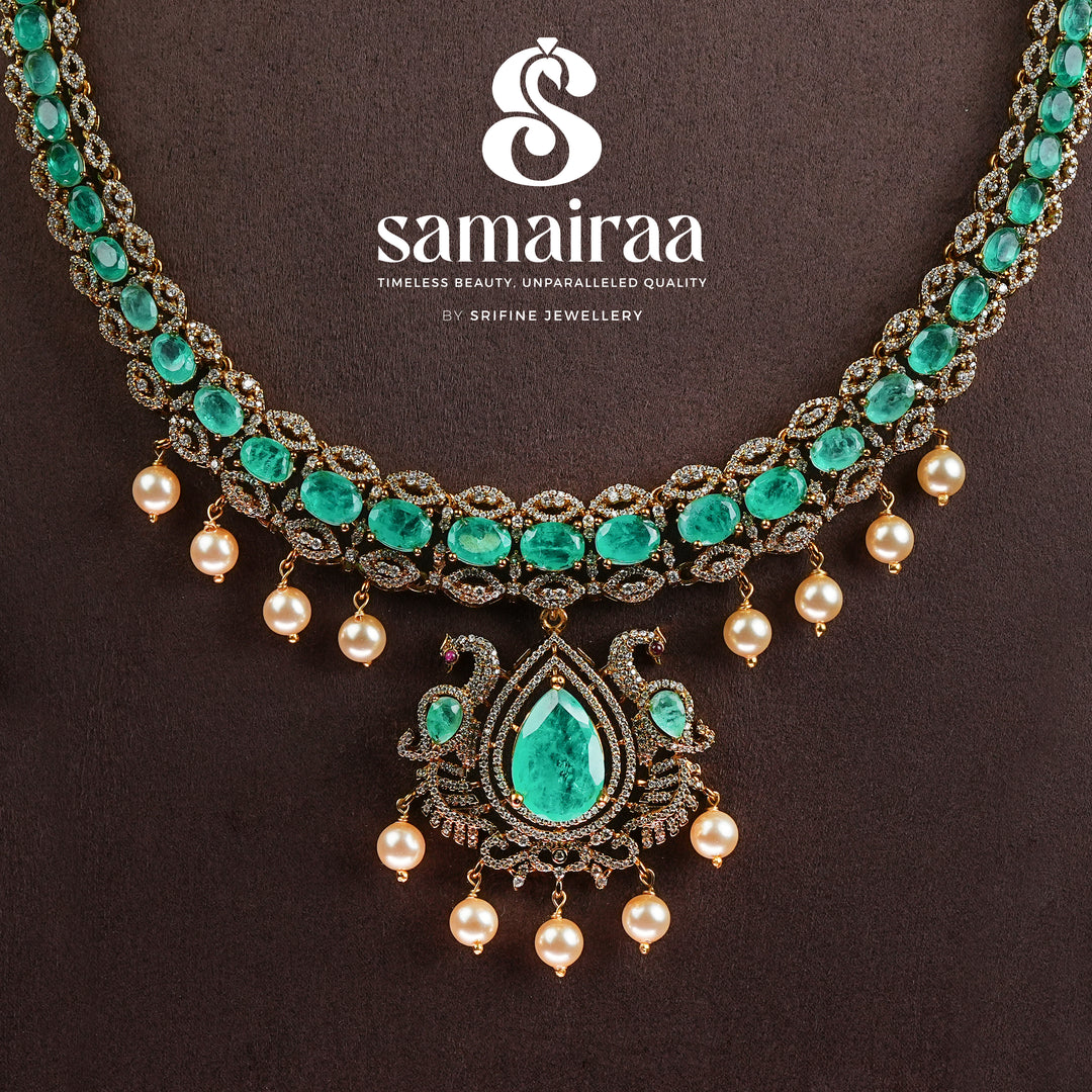 Samairaa emerald green victorian necklace set in 92.5 sterling silver with antique gold finish, pearl hangings and royal bridal design by Sri Fine Jewellery, Hyderabad.