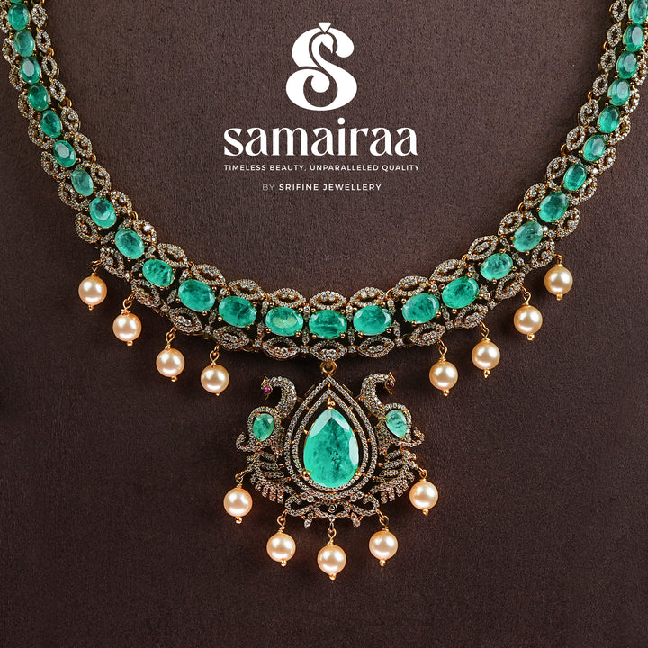 Samairaa emerald green victorian necklace set in 92.5 sterling silver with antique gold finish, pearl hangings and royal bridal design by Sri Fine Jewellery, Hyderabad.